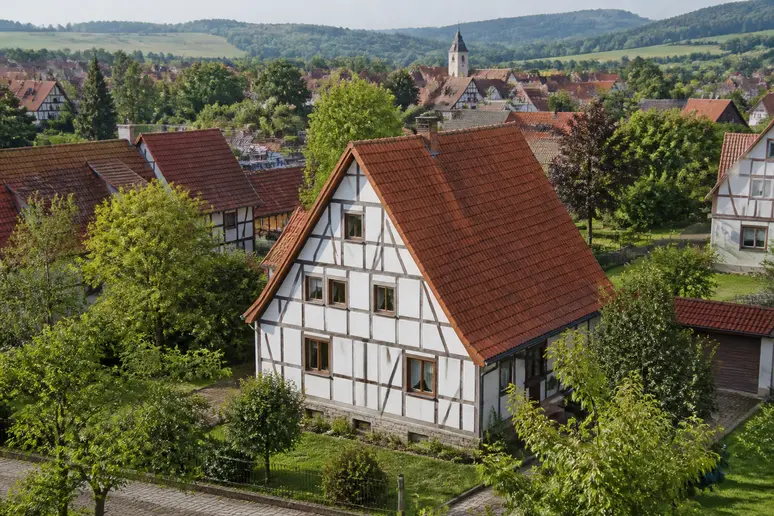 Ein Blick über ein deutsches Dorf, das die ideale Dachneigung eines traditionellen Sparrendachs im Einklang mit der Landschaft zeigt.