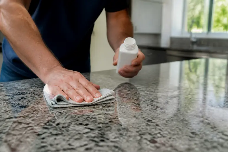 Auftragen des Imprägniermittels auf eine Granit Arbeitsplatte Küche mit einem Tuch
